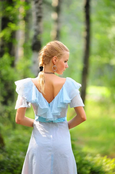 Young girl in a blue dress in the park Stock Photo