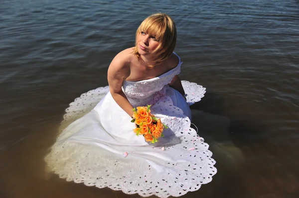 Bride dressed in wedding gown in water — Stock Photo, Image