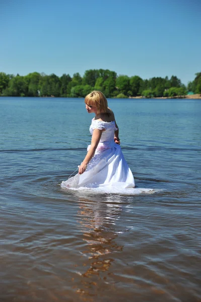 Mädchen im Brautkleid im Wasser — Stockfoto