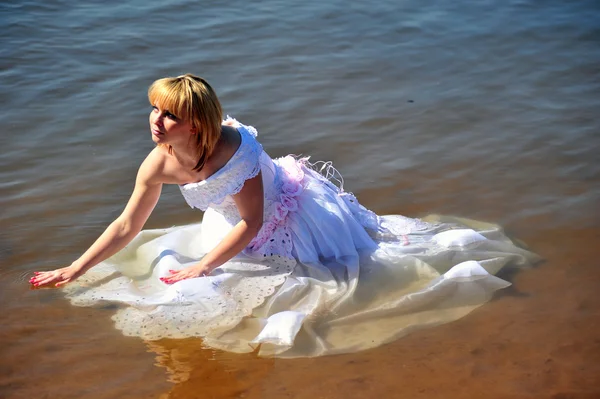 Дівчина у весільній сукні у воді — стокове фото