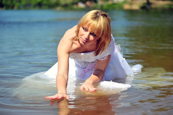 Menina em um vestido de noiva na água — Fotografia de Stock