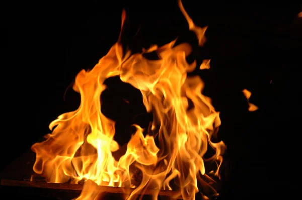Het vuur op een donkere achtergrond — Stockfoto