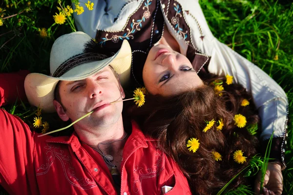 Casal feliz deitado em uma grama — Fotografia de Stock