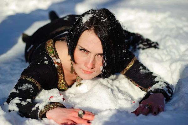 Meisje ligt in de sneeuw — Stockfoto