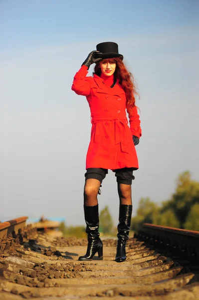 Молода руда жінка їде залізничними коліями — стокове фото