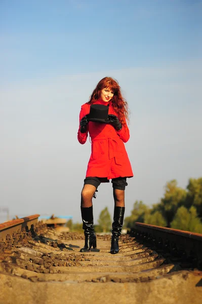 La giovane donna dai capelli rossi che va su binari ferroviari — Foto Stock