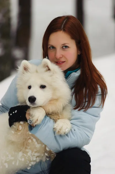 年轻的红发女子 在冬天用他的小狗萨摩耶 — 图库照片