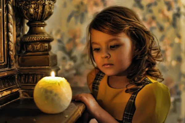 Retrato a la luz de las velas de una hermosa niña —  Fotos de Stock