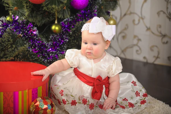 Meisje van de baby en de kerstboom — Stockfoto