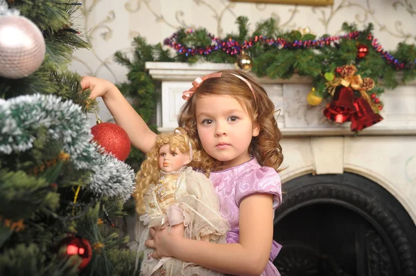 Kleines Mädchen mit einer Puppe in den Händen — Stockfoto