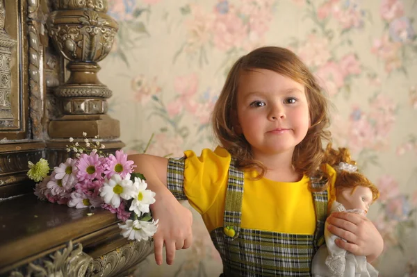 Liten flicka med en docka i händer. — Stockfoto