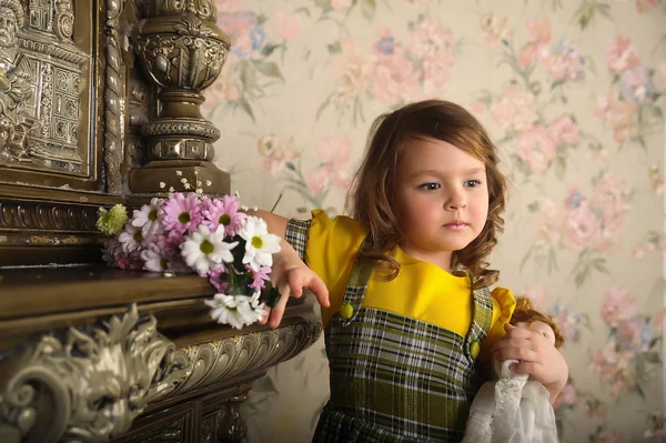 Liten flicka med en docka i händer. — Stockfoto