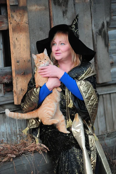 Bruja con un gato rojo —  Fotos de Stock