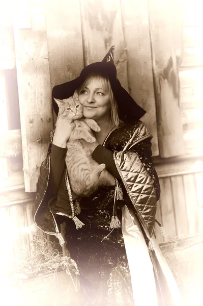 Bruxa com um gato vermelho — Fotografia de Stock