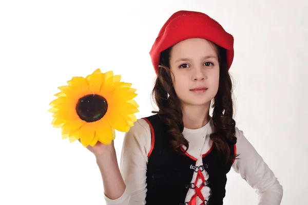 Flicka i röd hatt med solrosor i händerna — Stockfoto