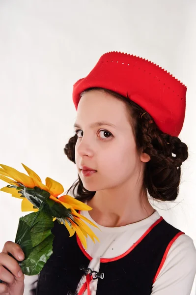 Mädchen mit rotem Hut und Sonnenblumen in der Hand — Stockfoto