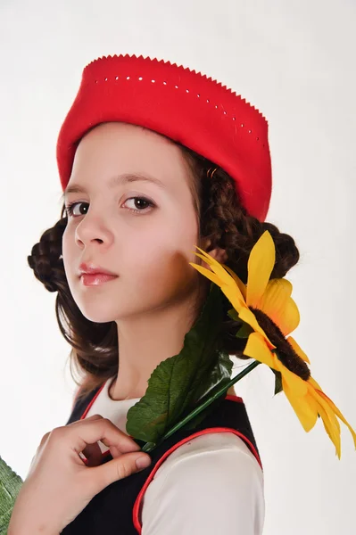 Chica en sombrero rojo con girasoles en sus manos —  Fotos de Stock