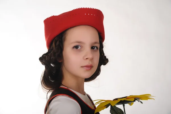 Flicka i röd hatt med solrosor i händerna — Stockfoto