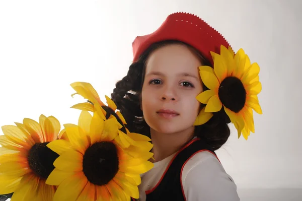 Chica en sombrero rojo con girasoles en sus manos — Foto de Stock