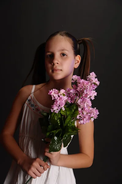 Flicka med en bukett av syrener — Stockfoto