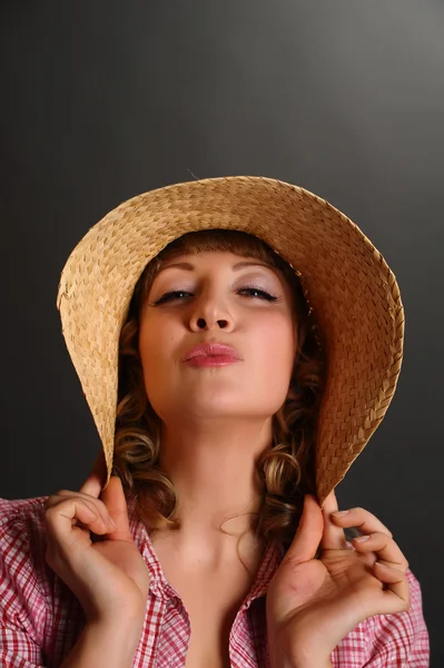 Porträtt av en söt ung kvinna som bär en stråhatt — Stockfoto