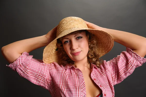Πορτρέτο του ένα χαριτωμένο νεαρή γυναίκα, φορώντας ένα ψάθινο καπέλο — Φωτογραφία Αρχείου