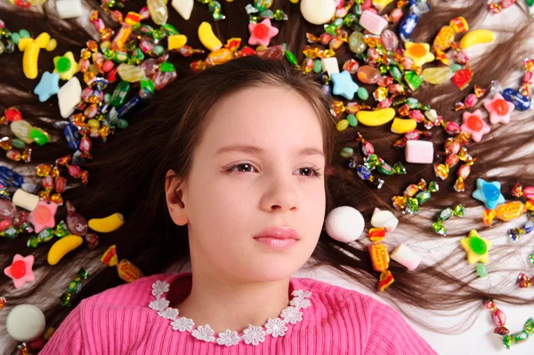 Красивая девушка со сладостями в волосах — стоковое фото