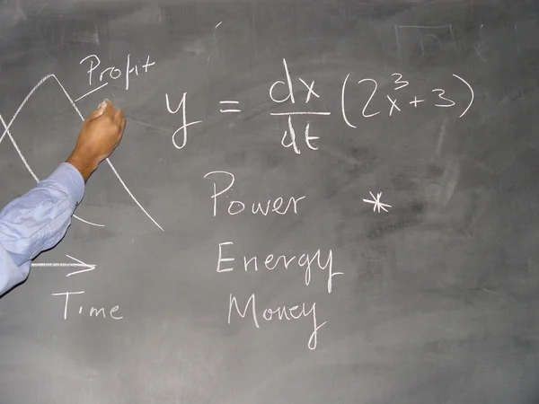 Teacher writing formula on blackboard — Stock Photo, Image