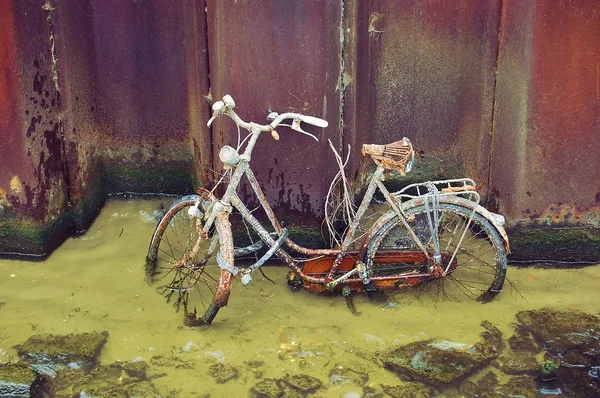 Un vélo à gauche pour rouiller dans un canal d'Amsterdam . — Photo