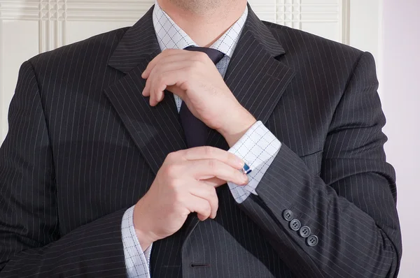 Een man dichtknopen zijn licht blauw shirt. — Stockfoto