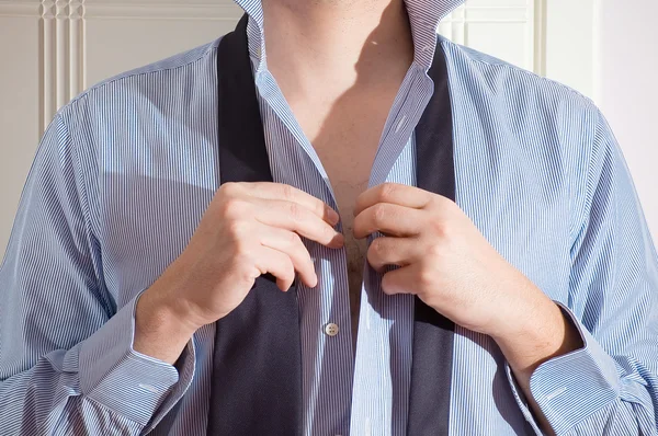 A young man getting dressed for work. — Stock Photo, Image