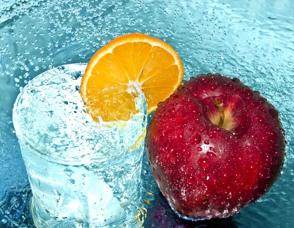 Jablko a pomeranč ve vodě kapky — Stock fotografie