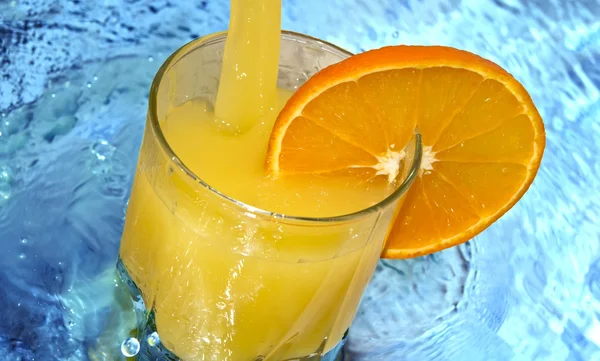 Jus d'orange avec des tranches d'orange dans le verre — Photo