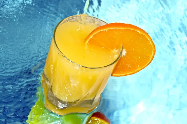 Suco de laranja com fatias de laranja no copo — Fotografia de Stock