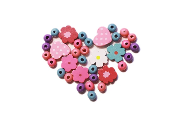 stock image Wooden colored beads lying in the shape of heart