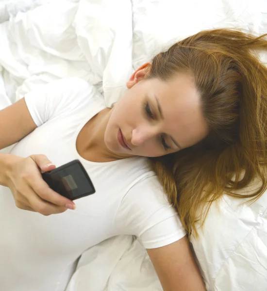 stock image Woman lying and reading sms