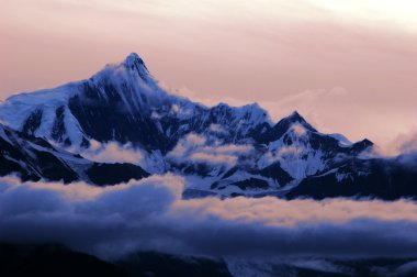 Landscape of snow mountains in the clouds clipart