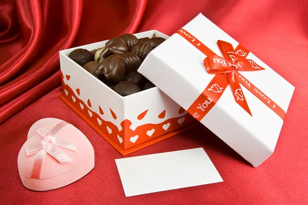 Κουτί Γλυκά Και Παρόν Στο Κόκκινο Φόντο — Φωτογραφία Αρχείου