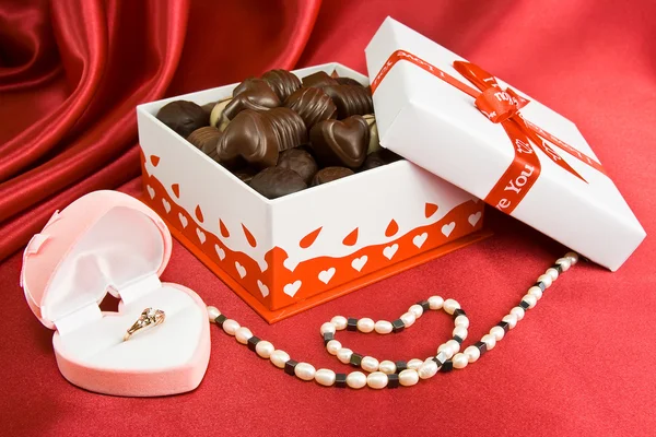 Box čokolád s současnosti a perly. — Stock fotografie