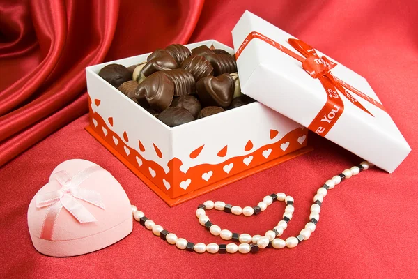 Caja de chocolates con presente y perlas . — Foto de Stock