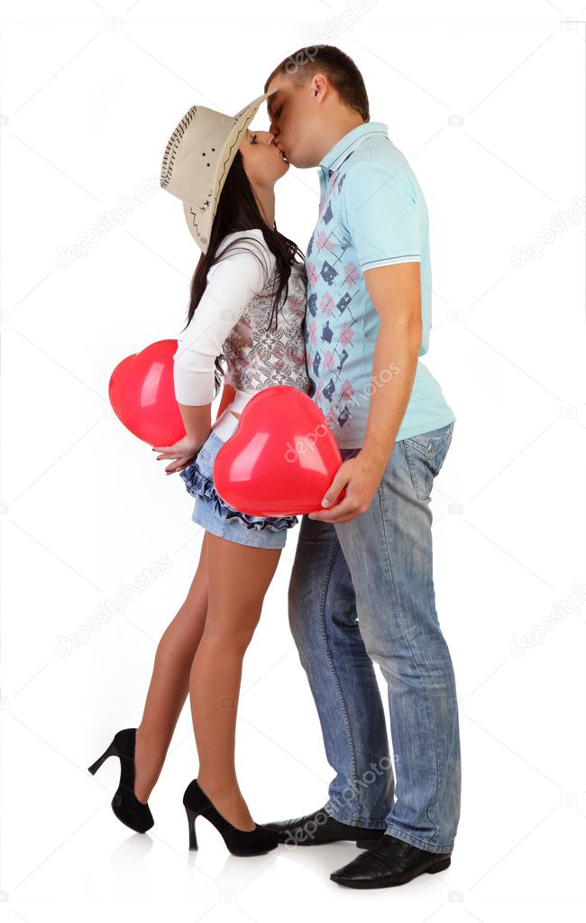 Young couple embraces, kisses and holds balloons - hearts isolat