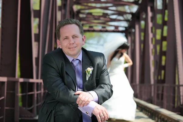 Bruidegom en de bruid op de spoorbrug — Stockfoto