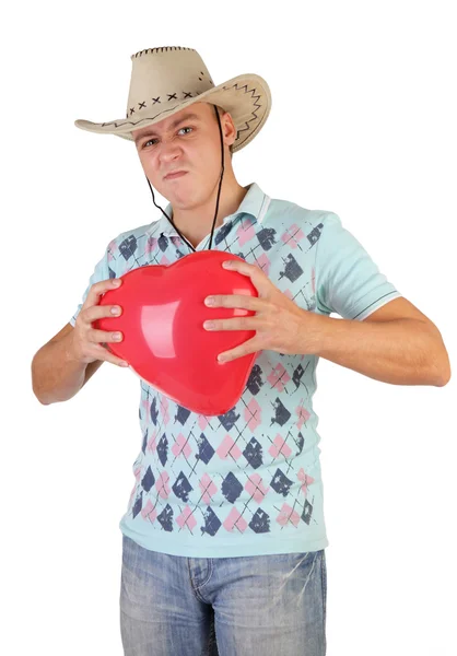 Ο νεαρός άντρας, κρατώντας ένα κόκκινο μπαλόνι καρδιά-διαμορφωμένα σε έναs άσπρο πλάτη — Φωτογραφία Αρχείου