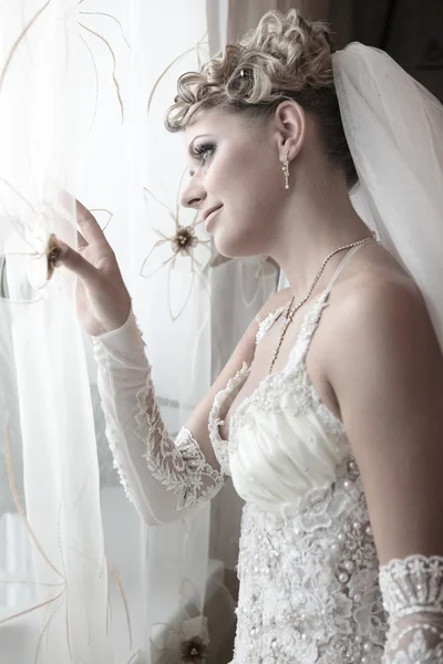 La bella sposa guarda fuori dalla finestra — Foto Stock