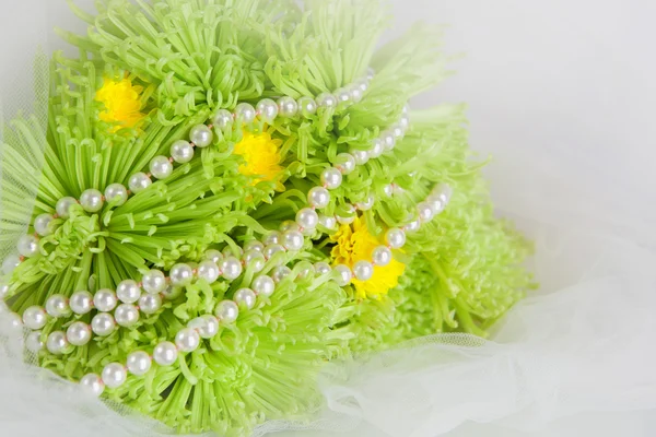 Ожерелье из жемчуга и букет хризантем — стоковое фото