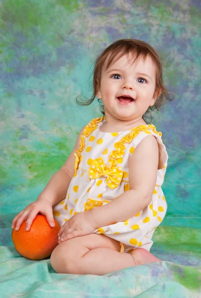 Маленькая девочка с апельсином — стоковое фото