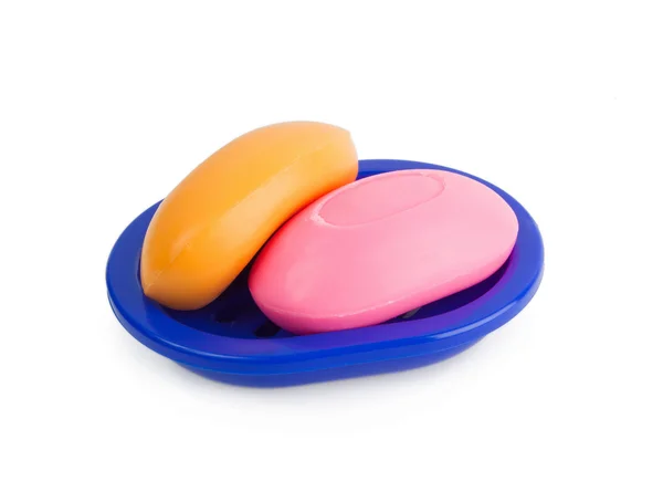 Stock image Soap of yellow and pinkcolor in a dark blue soap tray