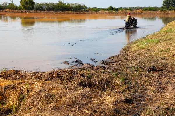 Boer met een handheld motor ploeg in rijst veld — Stockfoto