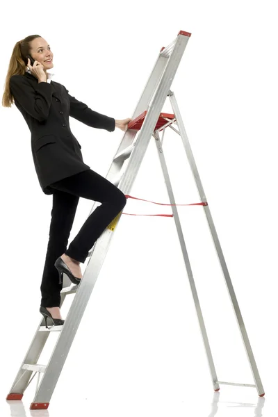 Joven mujer de negocios con teléfono celular en una escalera en el estudio de fondo blanco — Foto de Stock