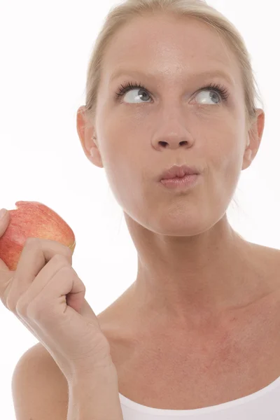 Молодая красивая белая женщина ест и держит яблоко в руке — стоковое фото